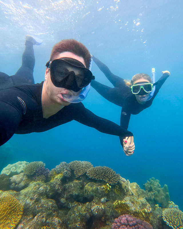 Couple snorkeling in the crystal-clear waters of the Whitsundays near Airlie Beach