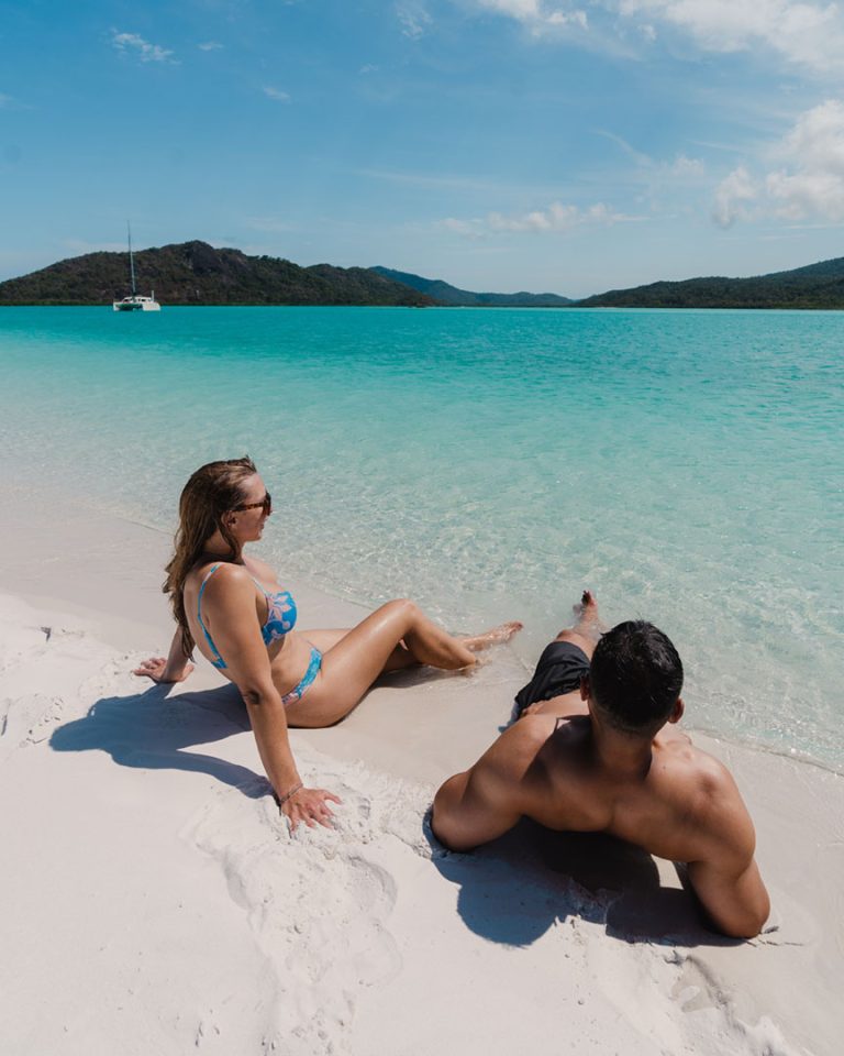 Couple relaxing on the beach at the Whitsundays, Airlie Beach